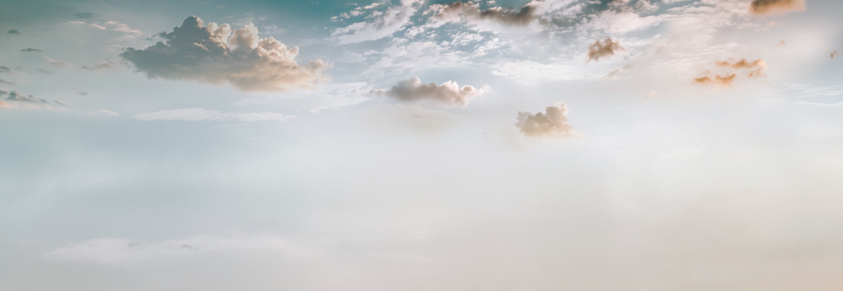 Panoramic view of a cloudy sky with soft light and pastel colors.