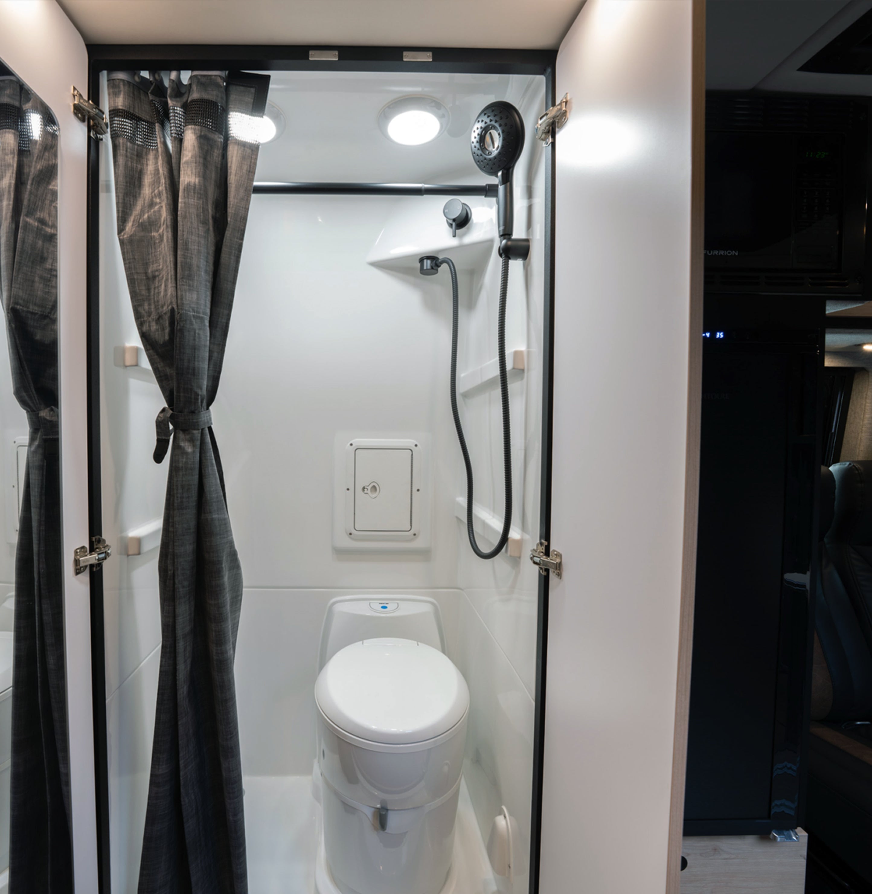 Wet bath with shower and toilet inside modern Camper Van or Class B RV, perfect for vanlife.