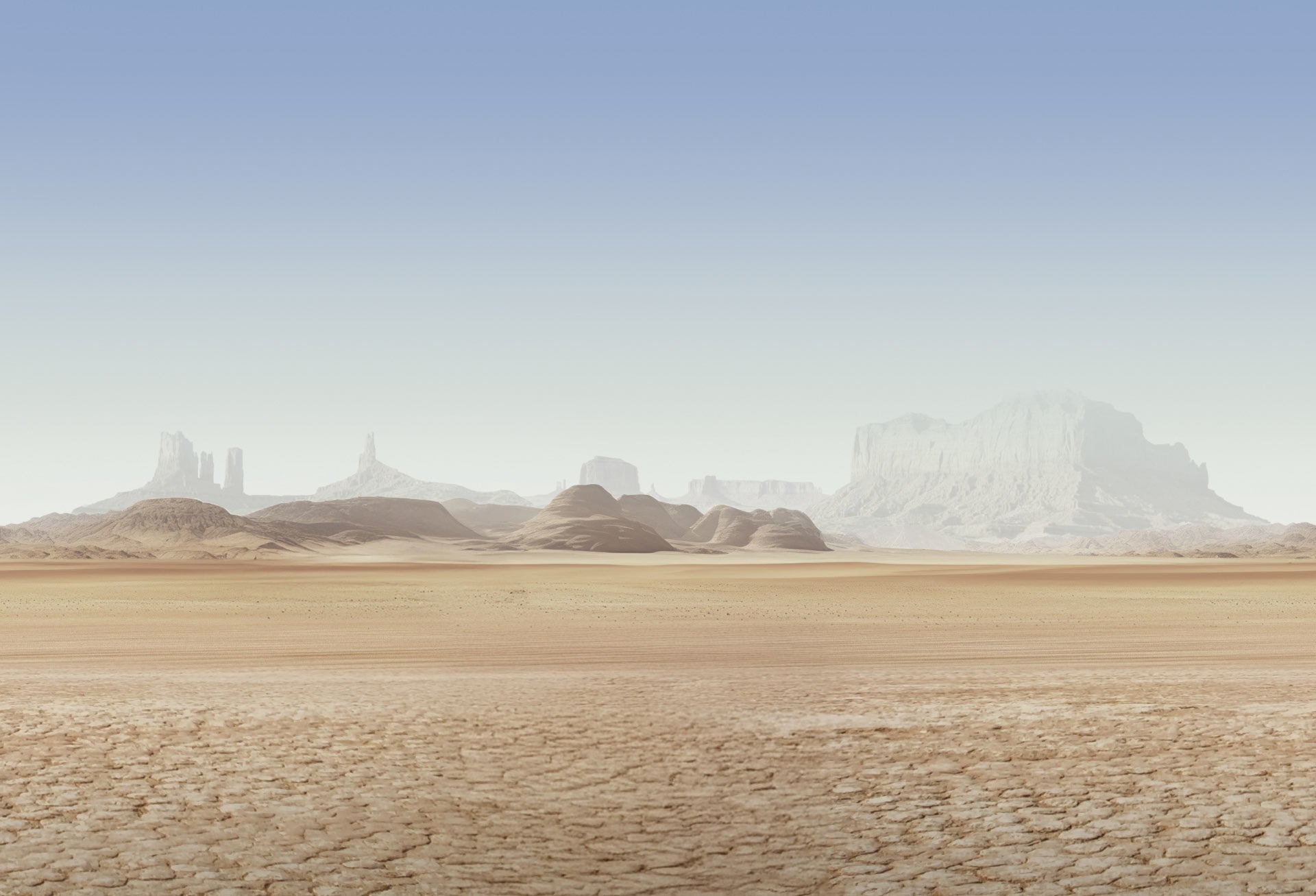 Desert landscape with dry cracked ground and distant rock formations, ideal for overland, offroad, and camper van adventure travel.