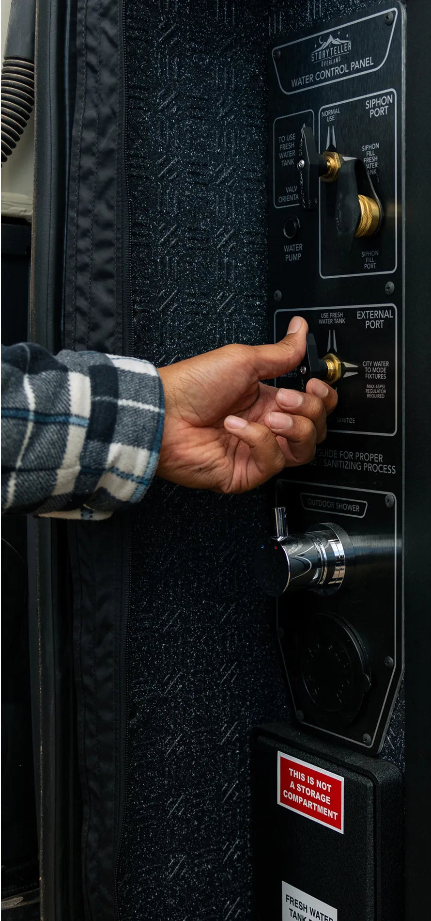 Hand adjusting water control panel in adventure van, ideal for campervan, vanlife, overlanding.