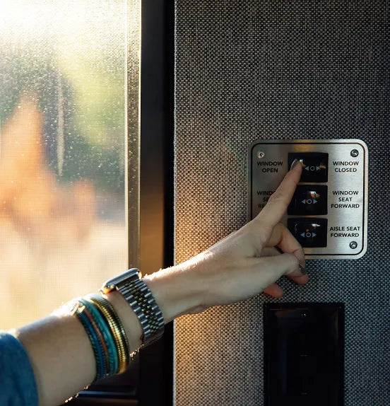 Camper Van interior control panel with hand pressing window switch in adventure van