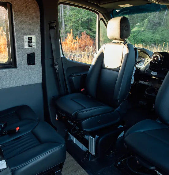 Modern interior seating and table controls in adventure camper van, ideal for vanlife and road trips.