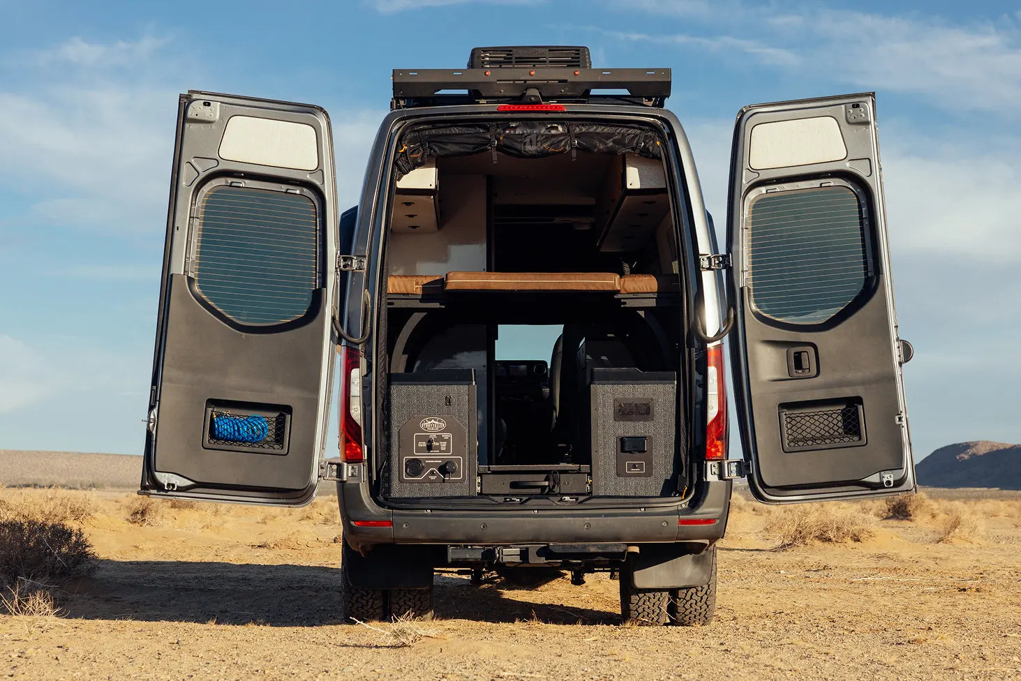 Rear view of adventure camper van with storage and bed, perfect for overlanding or vanlife