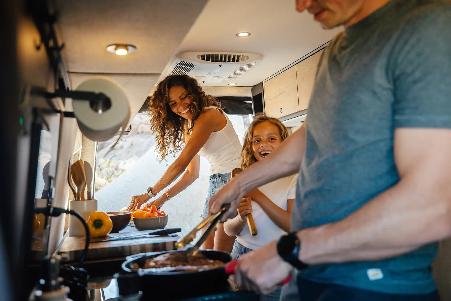Family cooking inside camper van, enjoying vanlife and adventure travel lifestyle