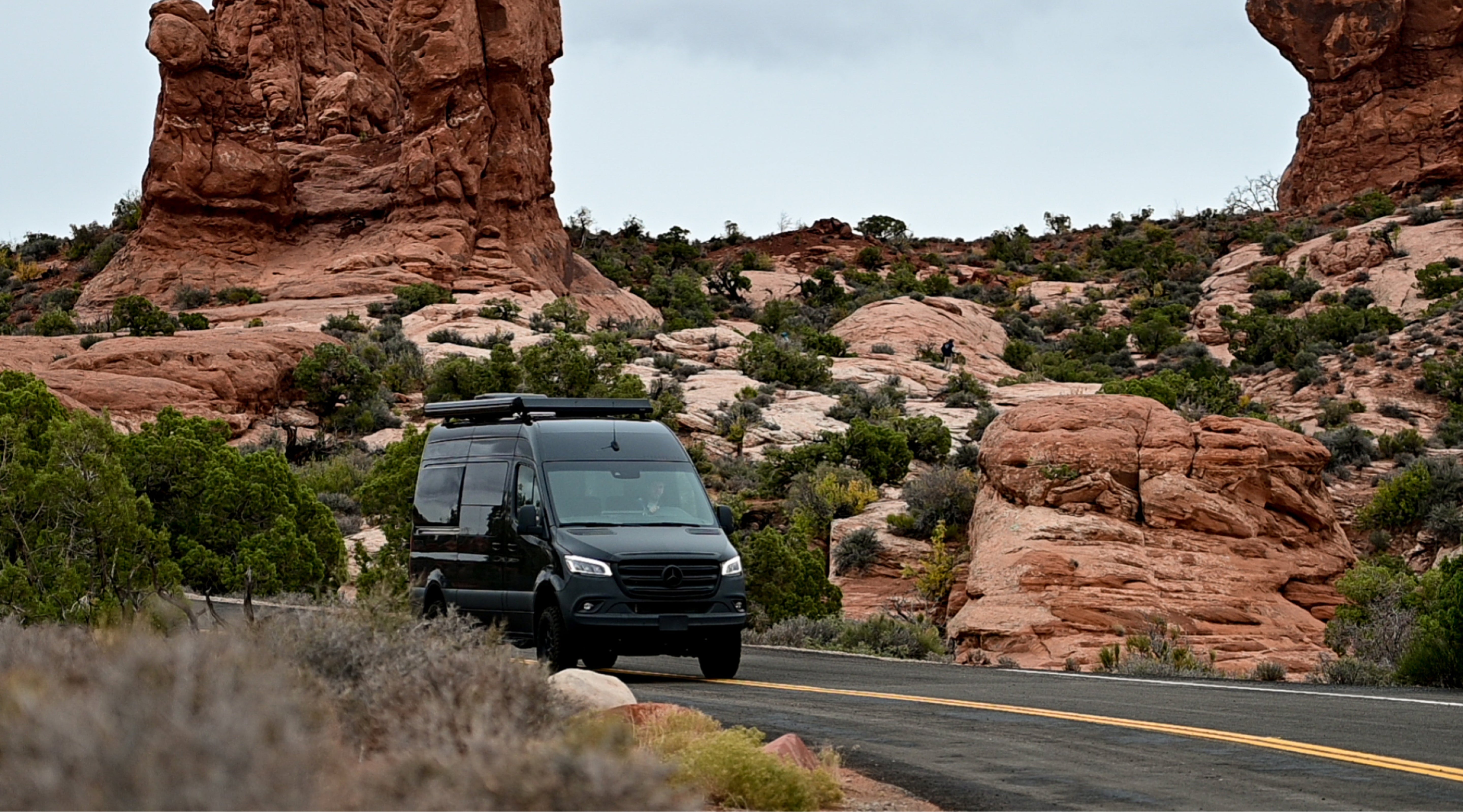 Adventure van, Sprinter 4x4 camper van driving through rocky desert landscape, perfect for overlanding and van life