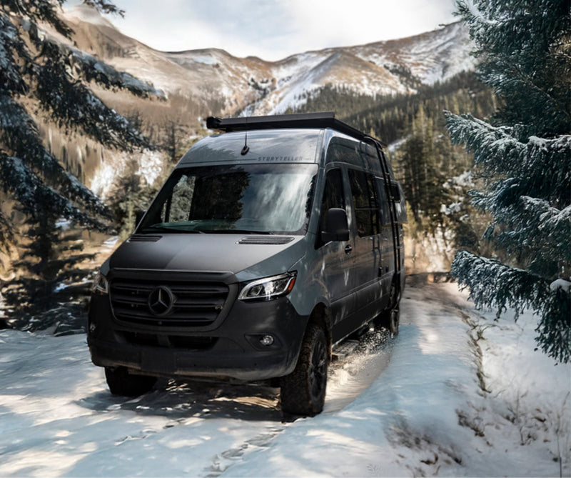 Sprinter 4x4 camper van driving through snowy forest, off-road adventure van, overlanding vehicle