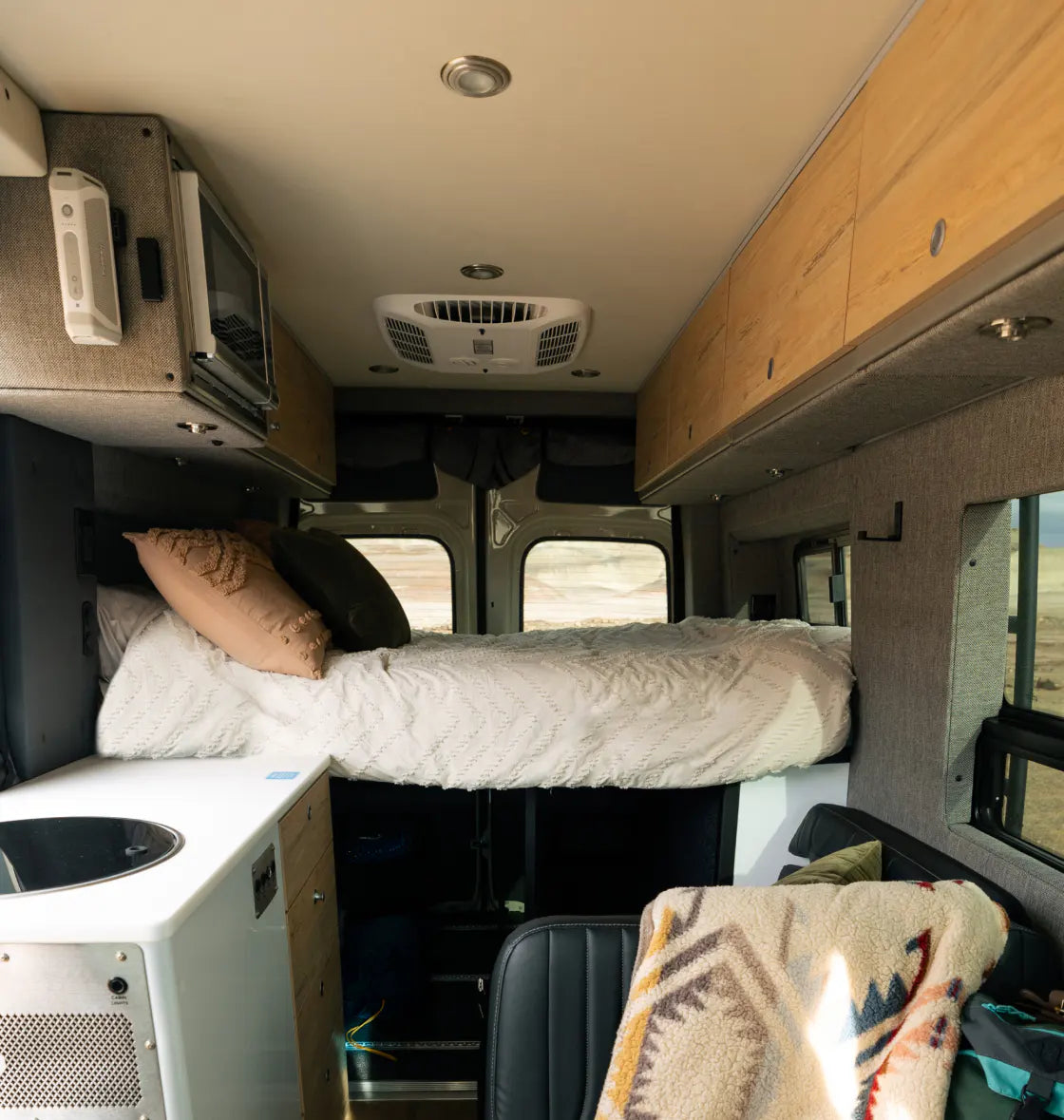 Interior of adventure van with bed, storage, and kitchenette for vanlife or overlanding