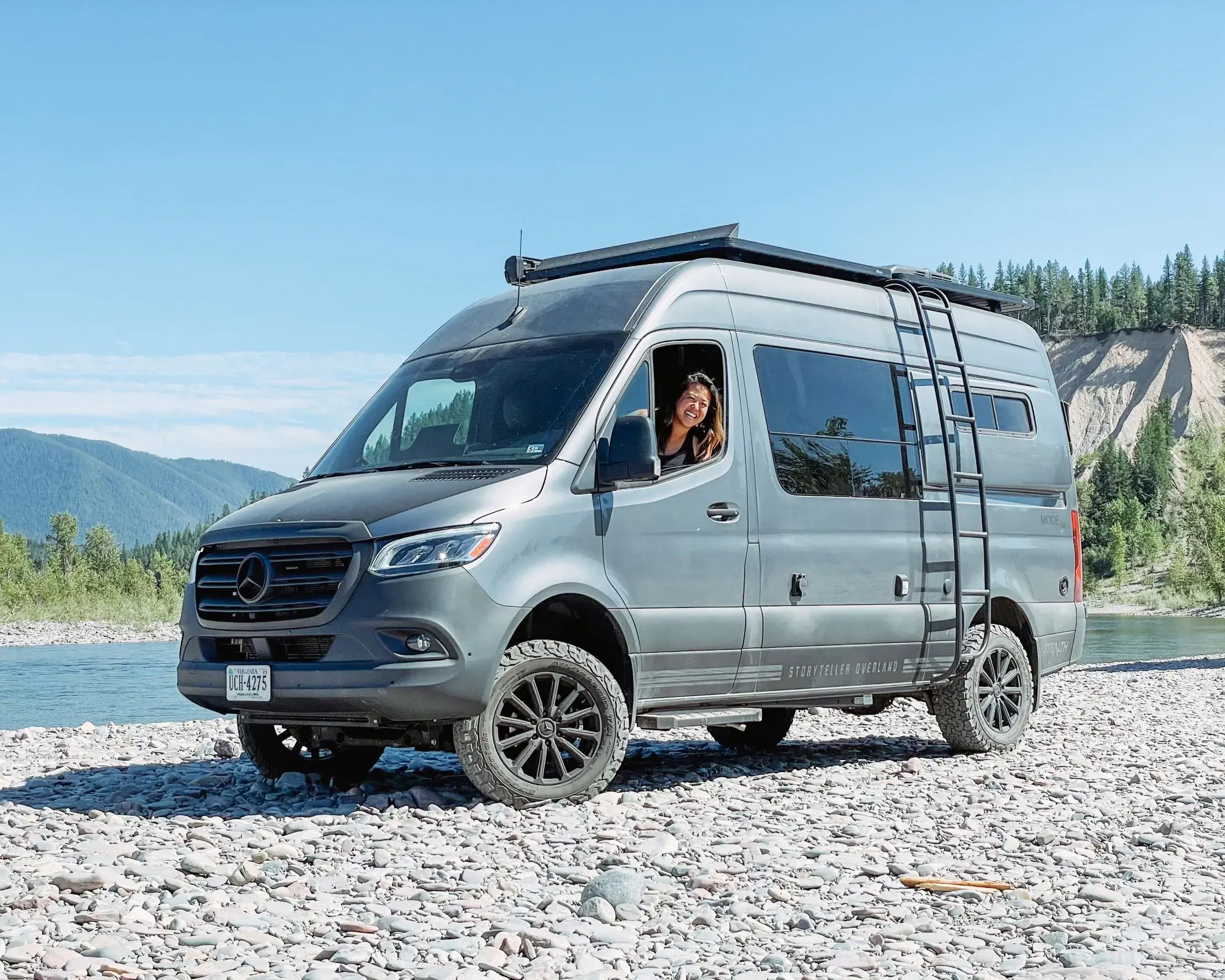 Sprinter 4x4 camper van on rocky riverbank, adventure van life, offroad overlanding vehicle