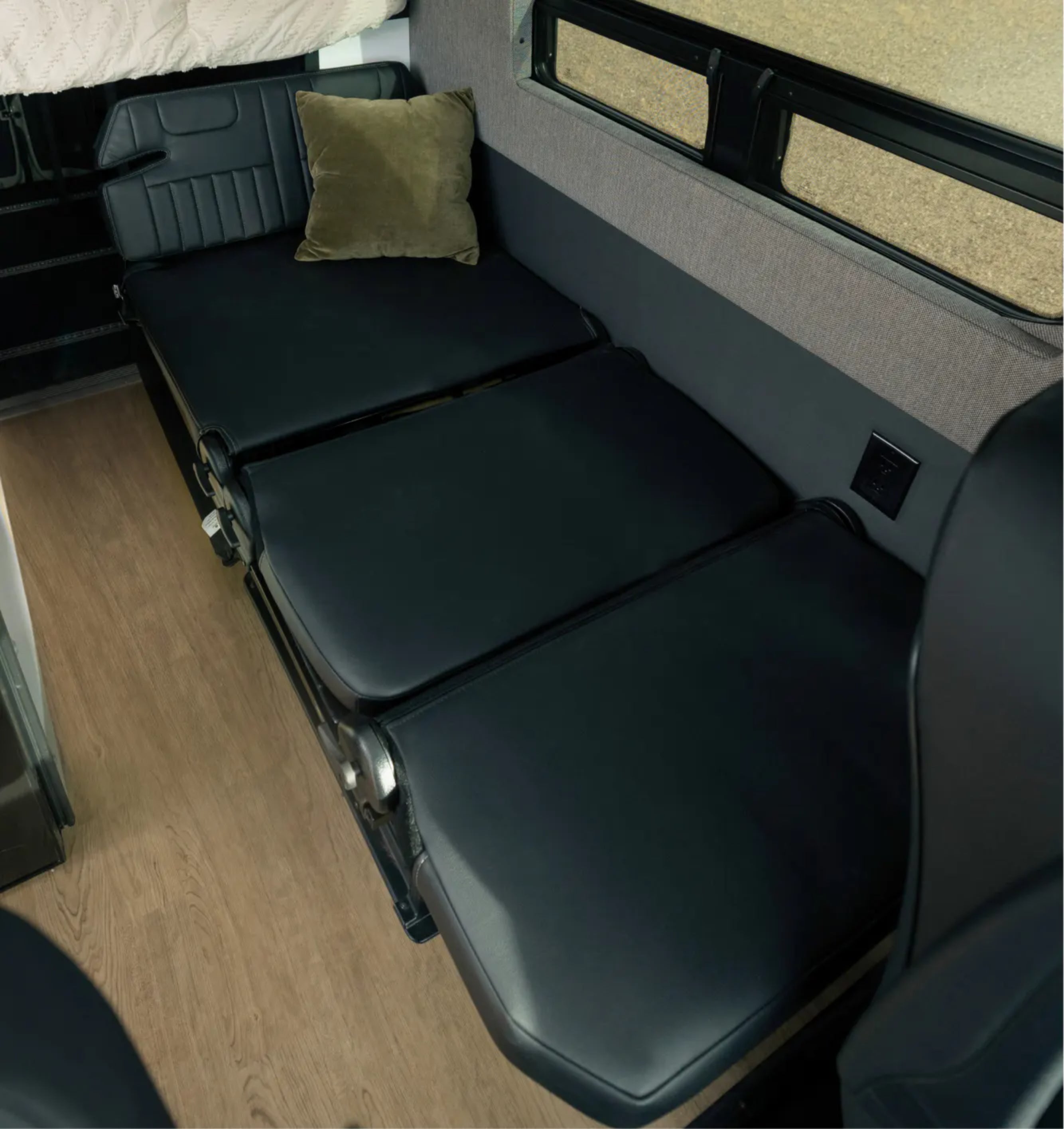 Convertible bed inside camper van, adventure van or Class B RV with modern interior.