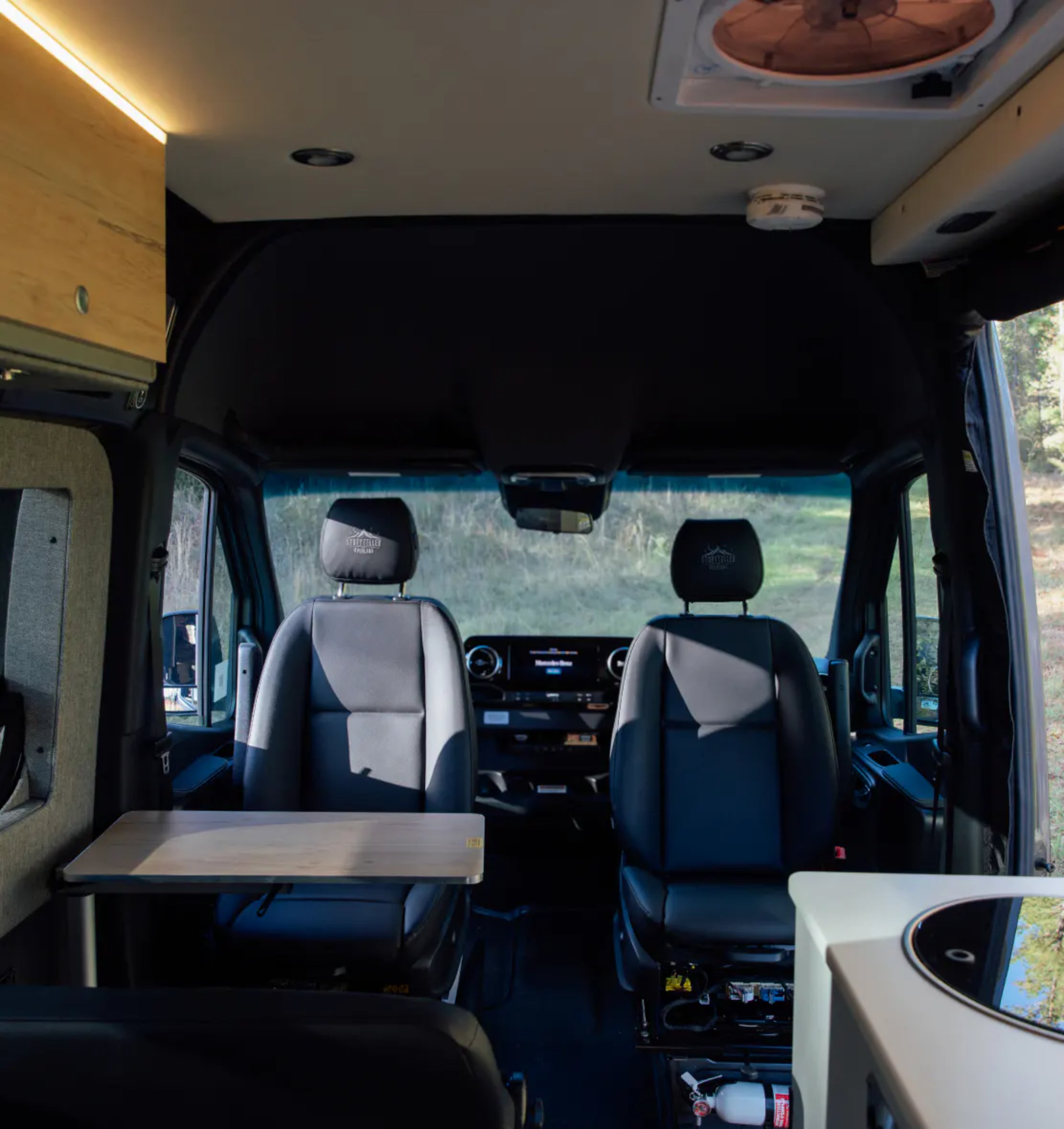 Luxury camper van interior with swivel seats, table, and modern vanlife features for adventure travel