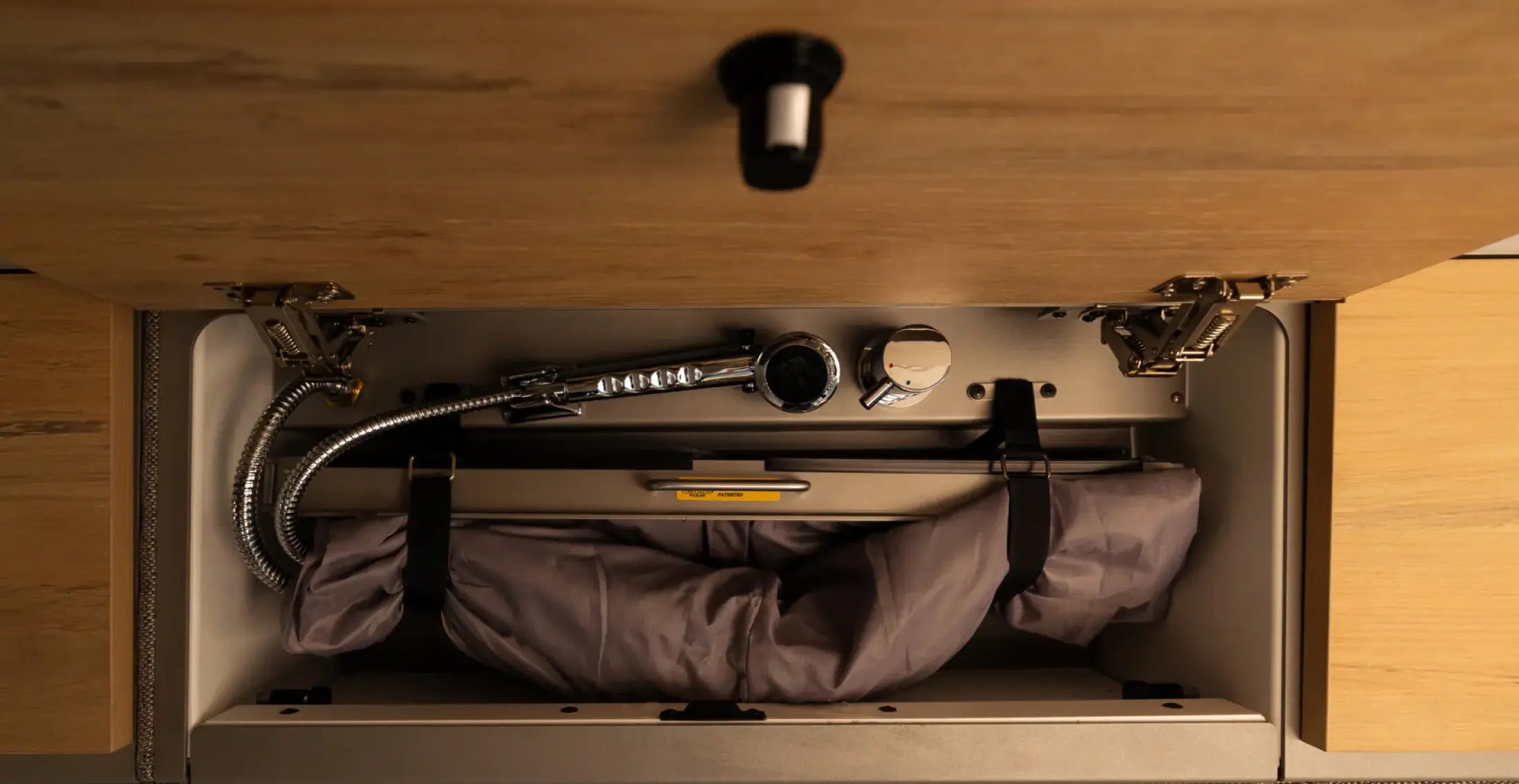 Camper van interior cabinet with built-in faucet and storage, ideal for vanlife adventure travel.