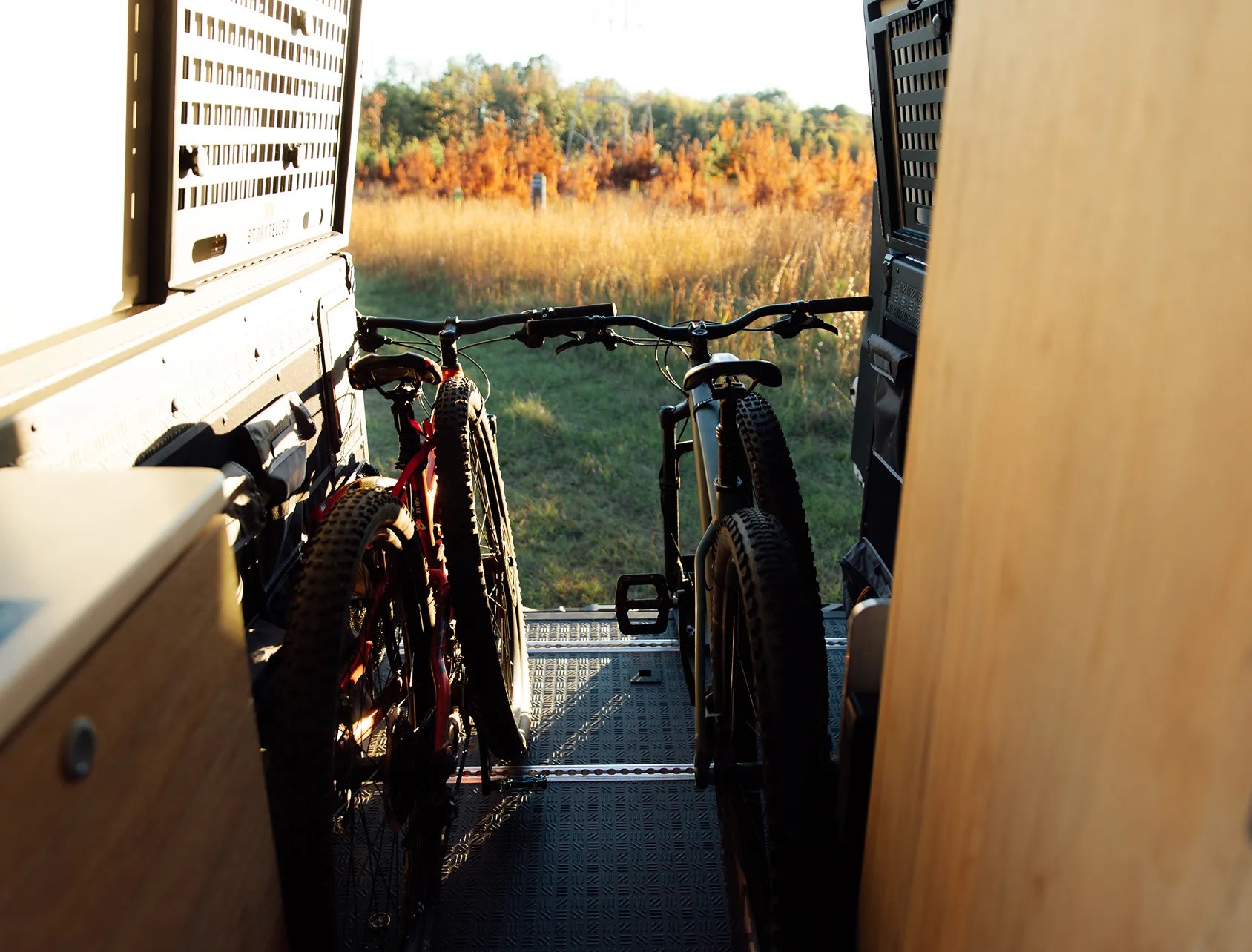 Two mountain bikes inside adventure van, camper van interior setup for vanlife road trip.
