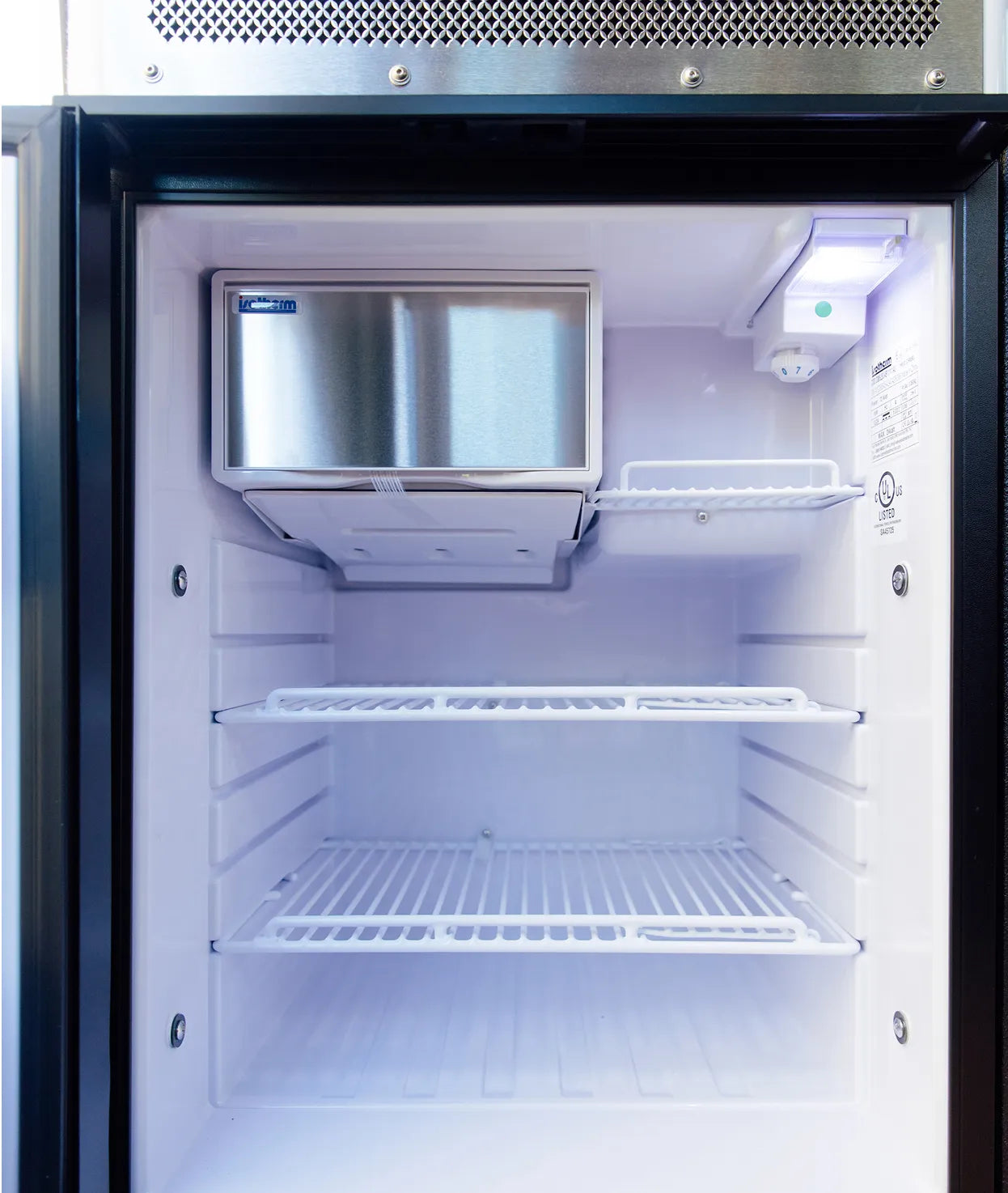 Empty camper van fridge interior with freezer, ideal for vanlife, overlanding, road trip RV