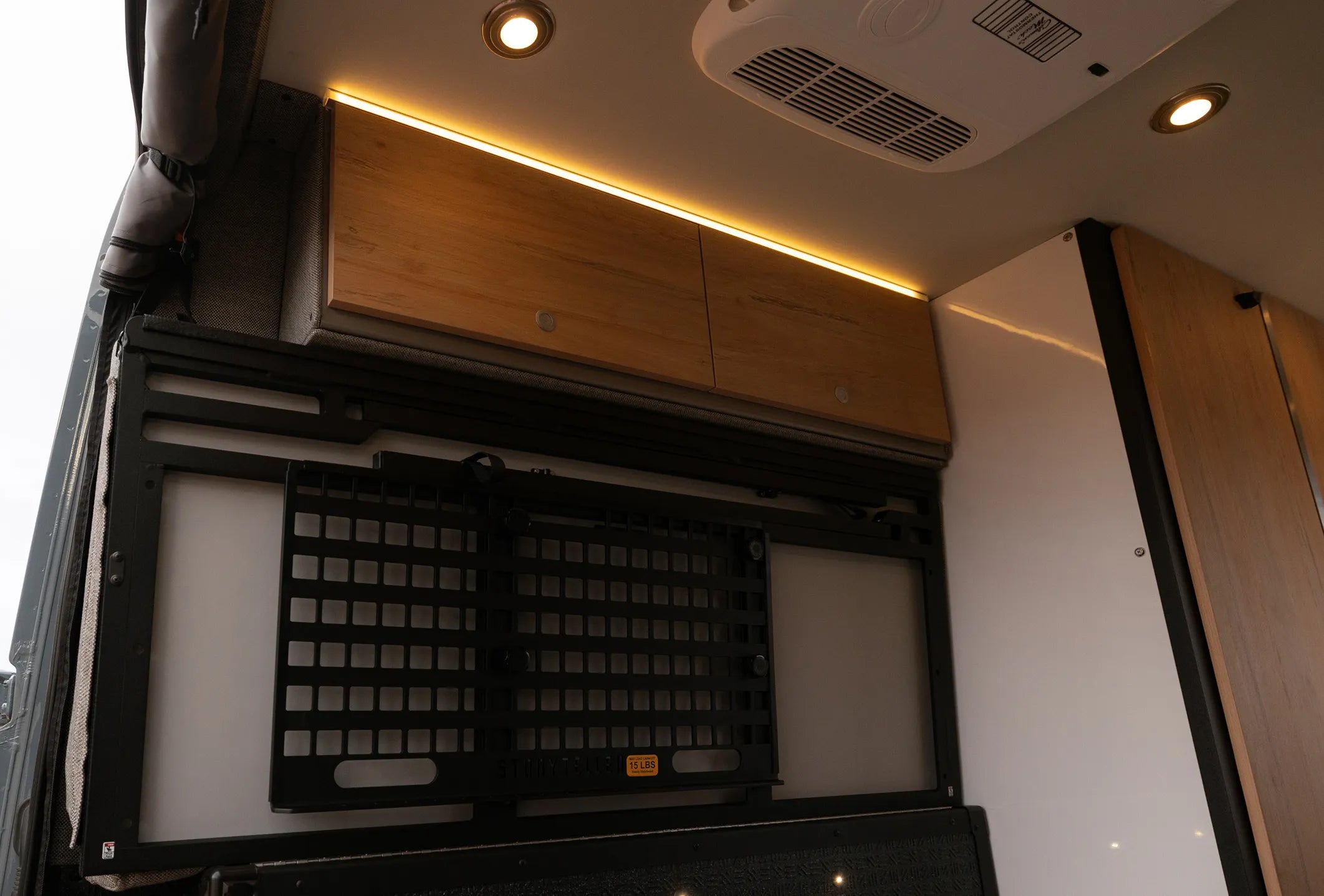 Overhead cabinets and gear storage inside modern camper van, ideal for vanlife, overlanding, Class B RV.