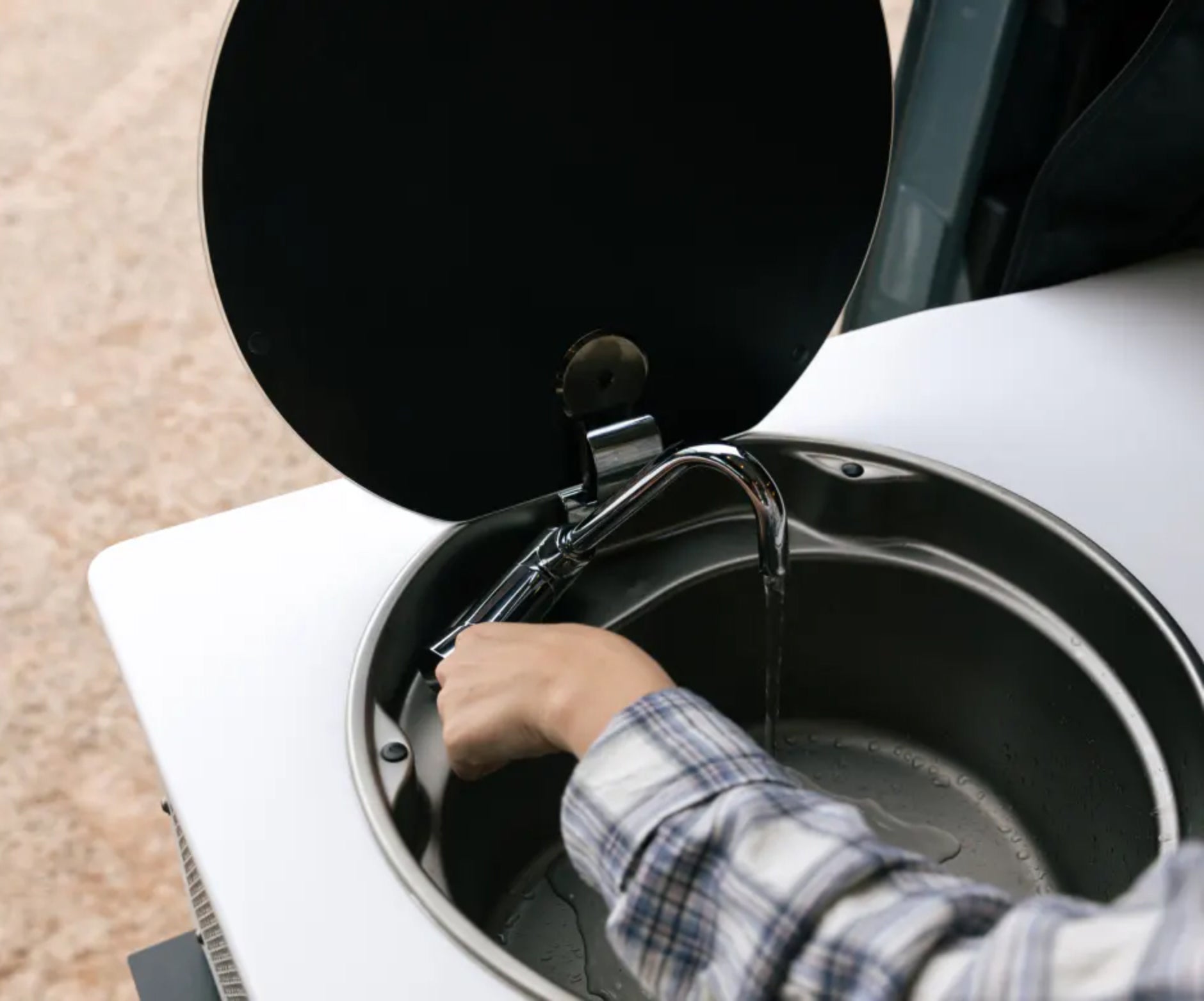 Compact stainless sink and faucet in a camper van, ideal for vanlife, overlanding, road trips
