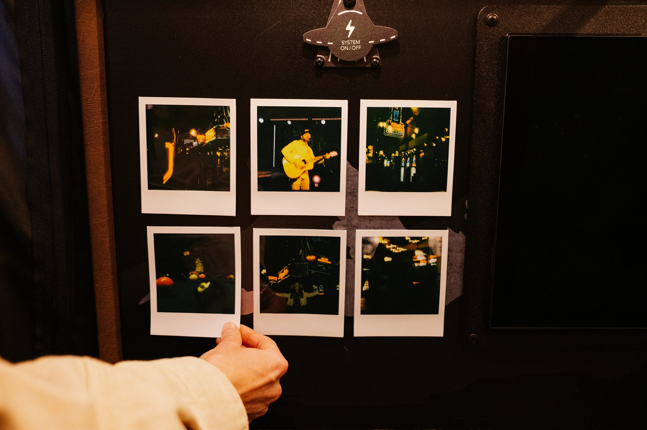 Hand organizing Polaroid photos inside an adventure van, perfect for camper van road trips