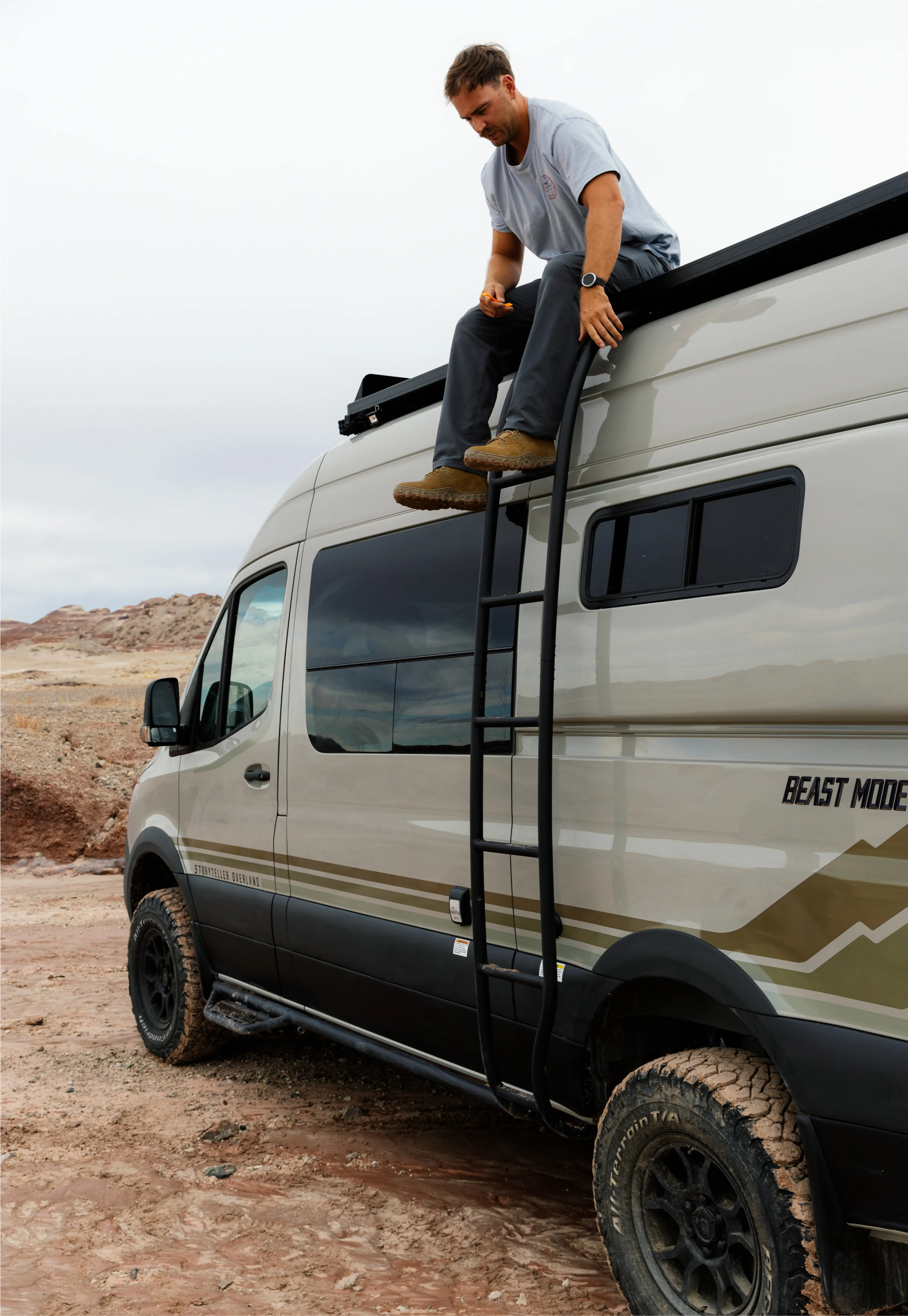 Beast MODE adventure van with roof ladder, off-road tires, overland campervan in rugged terrain