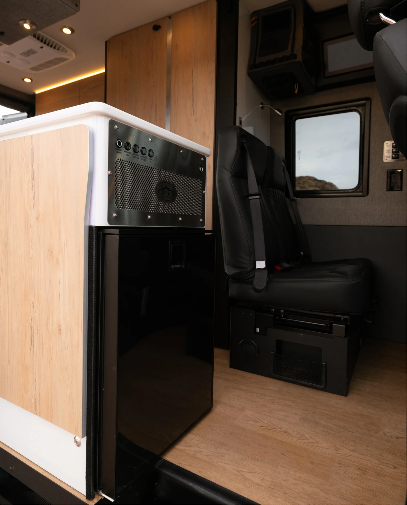 Interior of camper van with modern kitchenette, black leather seats, ideal for vanlife and overlanding