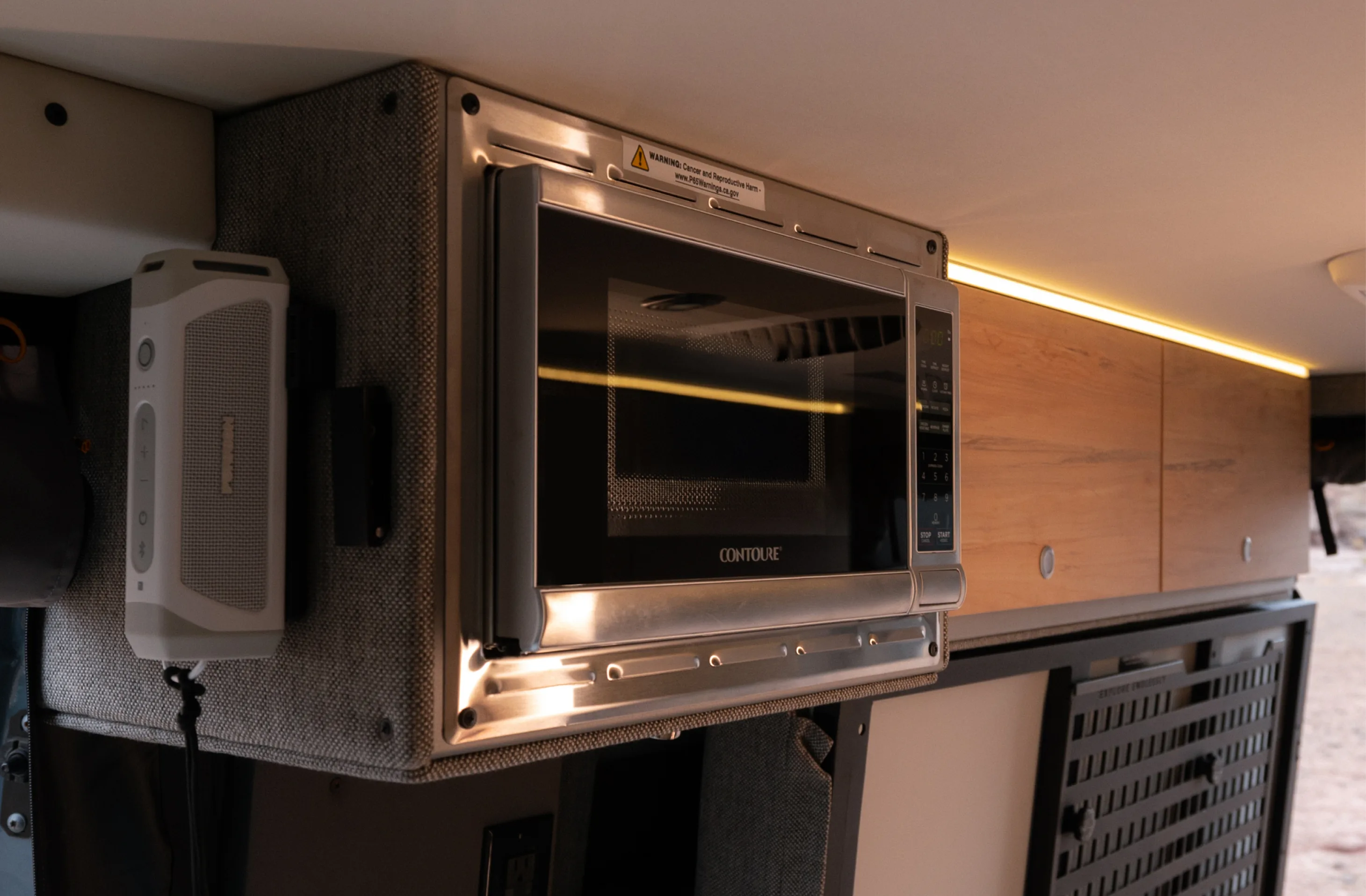 Built-in microwave inside adventure van interior, ideal for camper van, vanlife, overland travel
