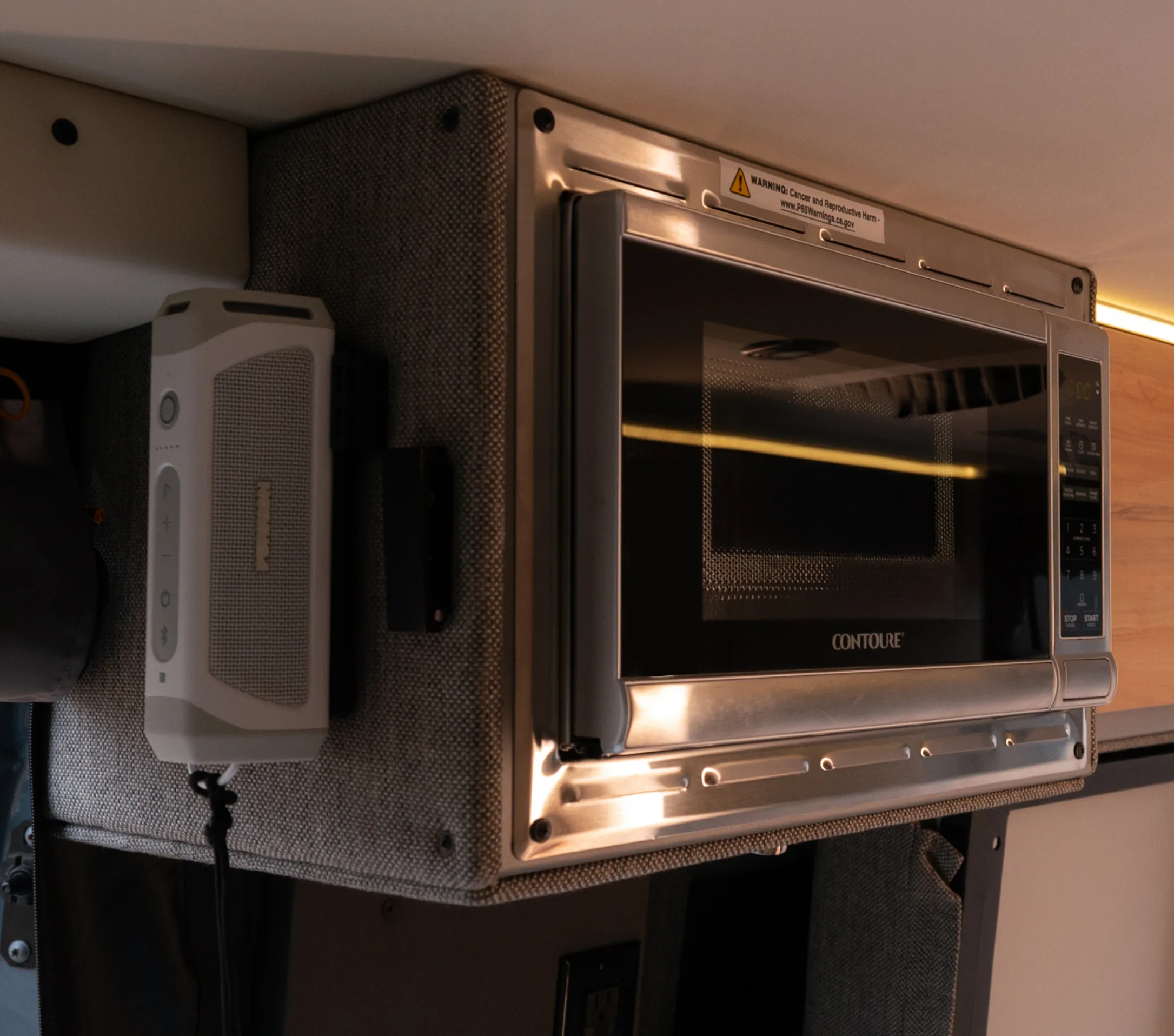 Microwave and control panel in Beast MODE camper van interior, adventure van kitchen detail