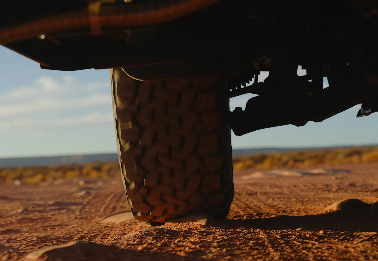 Offroad tire of an adventure van or overland camper van on rugged dirt terrain