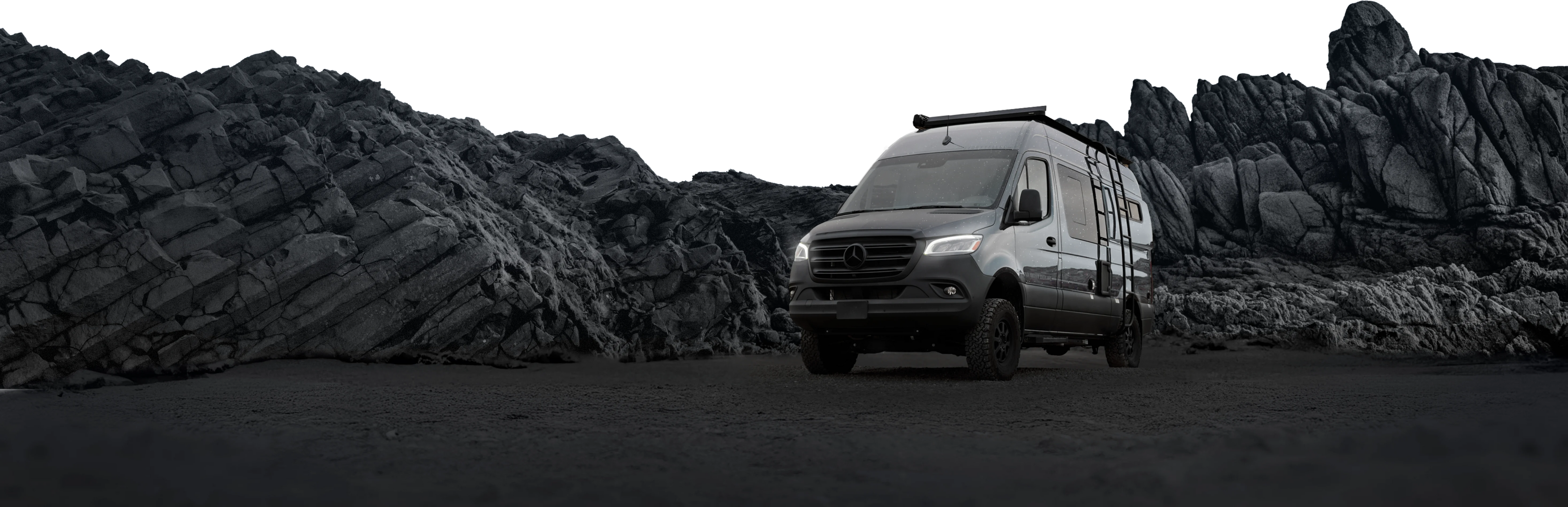Sprinter 4x4 camper van adventure rig parked on rugged rocky terrain, ideal for overlanding
