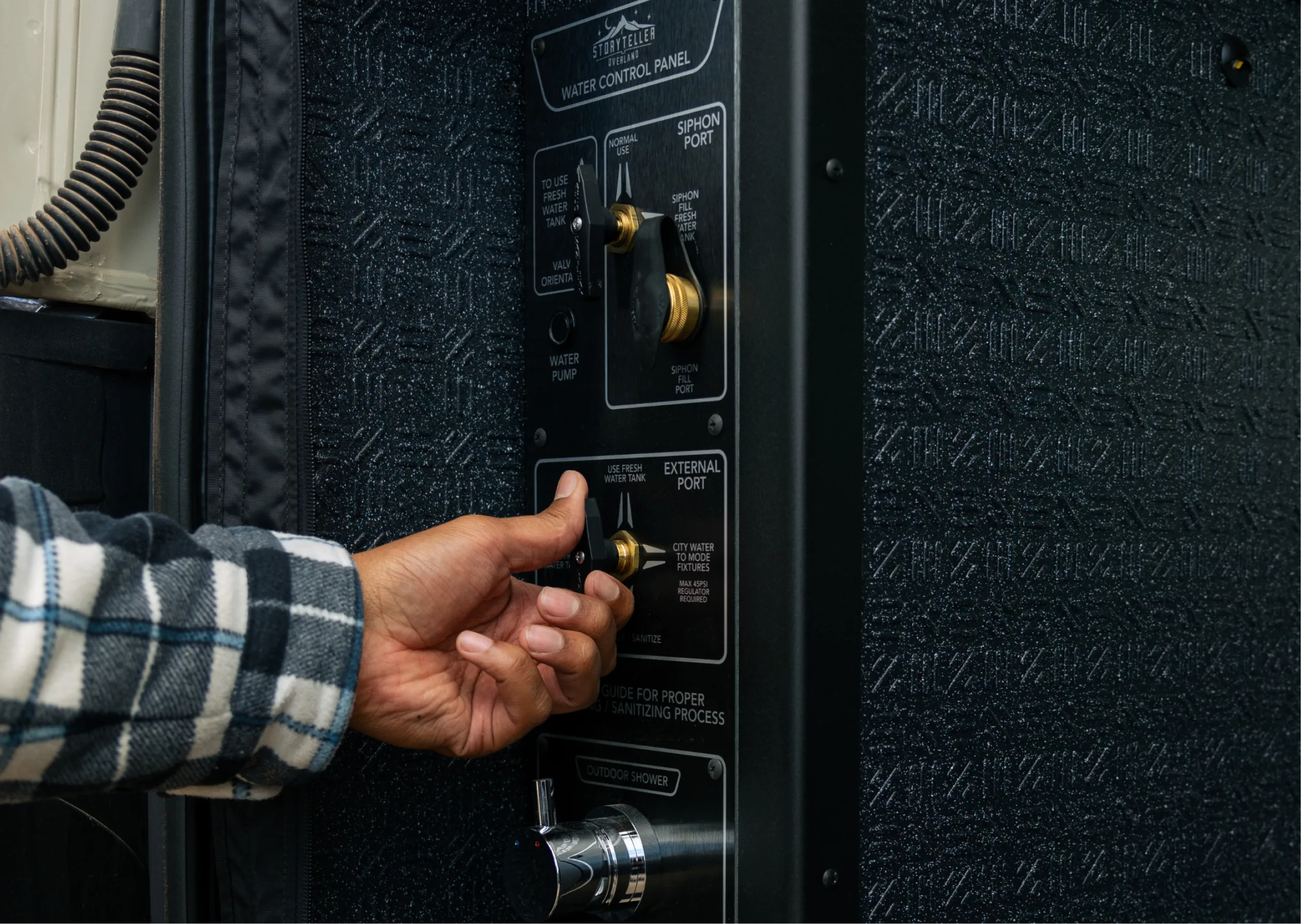 Adjusting water control panel inside camper van for overland adventure travel